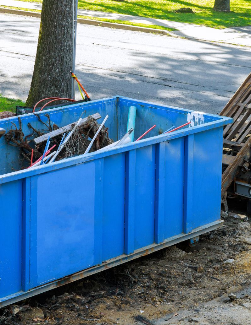Blue roll-off dumpster filled with construction debris
